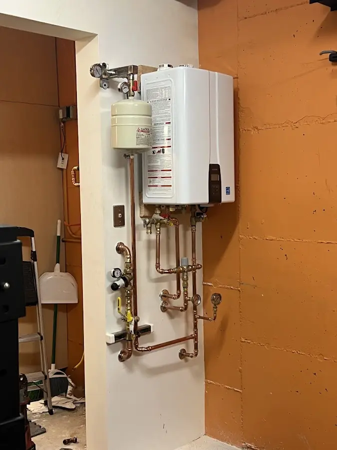 Plumbing technician inspecting water heater connections in Sierra Ridge